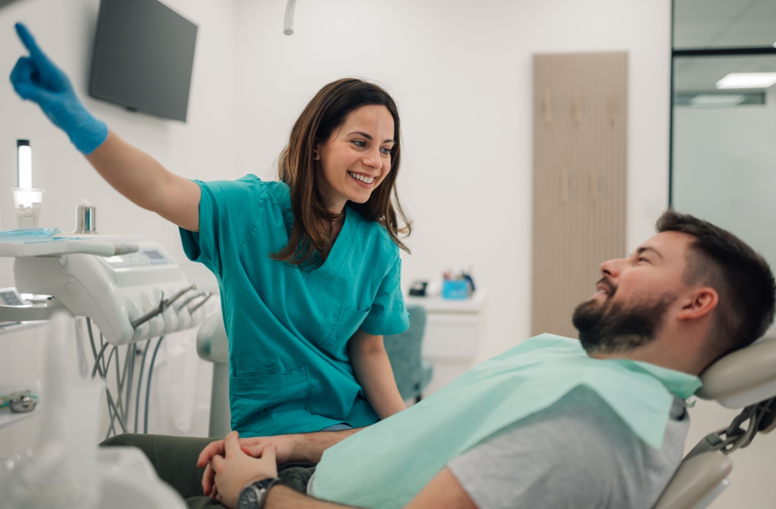 A dentist going over a treatment plan and how long dental freezing will last with a dental patient.